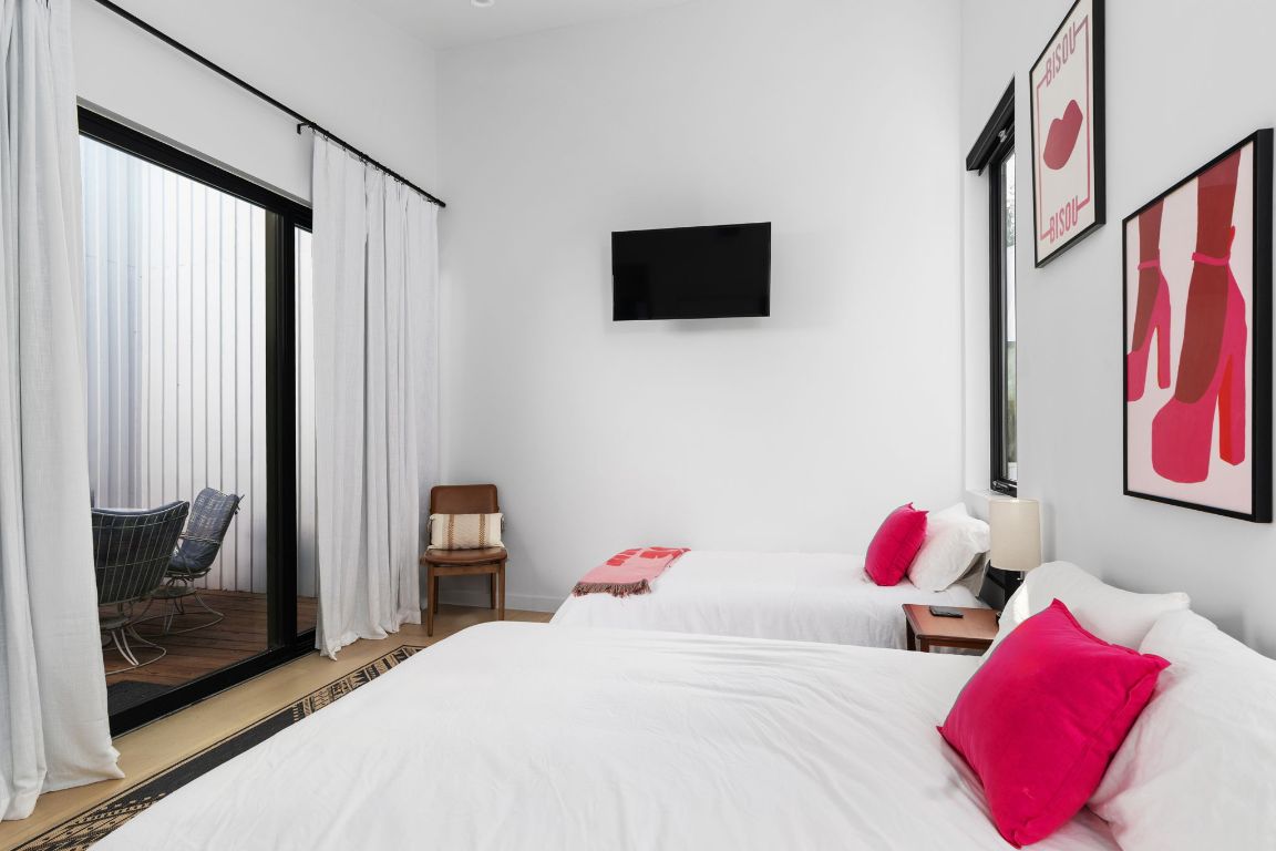 1206 Luna Street Austin, TX 78721 - Photo 20 of 27 a bedroom with a bed and a flat tv screen