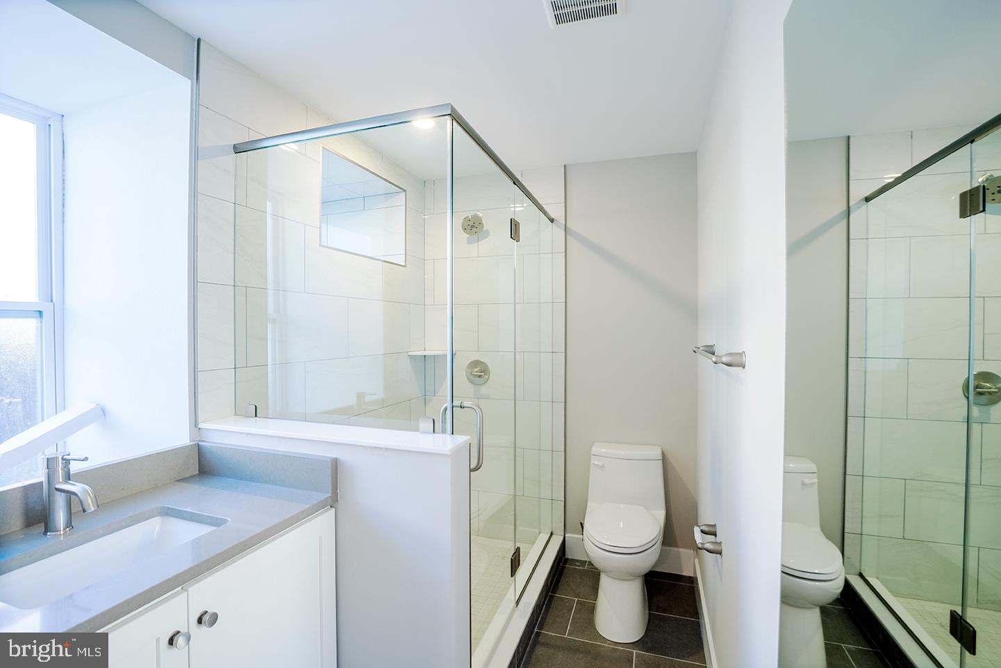 129 South 49th Street, Unit 1F Philadelphia, PA 19139 - Photo 11 of 18 a bathroom with a granite countertop sink toilet and shower