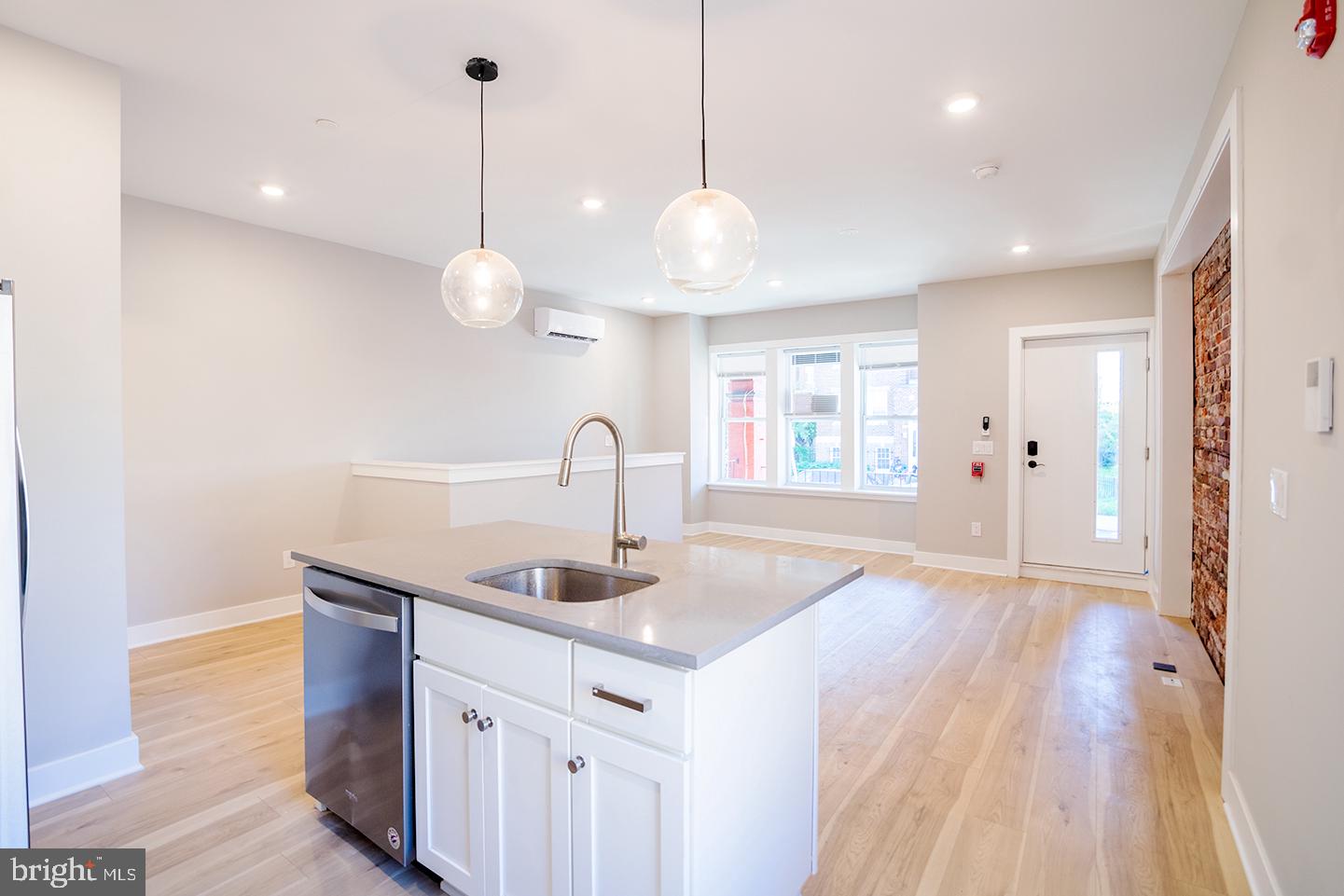 129 South 49th Street, Unit 1F Philadelphia, PA 19139 - Photo 5 of 18 a kitchen with stainless steel appliances granite countertop a sink a window and wooden floor