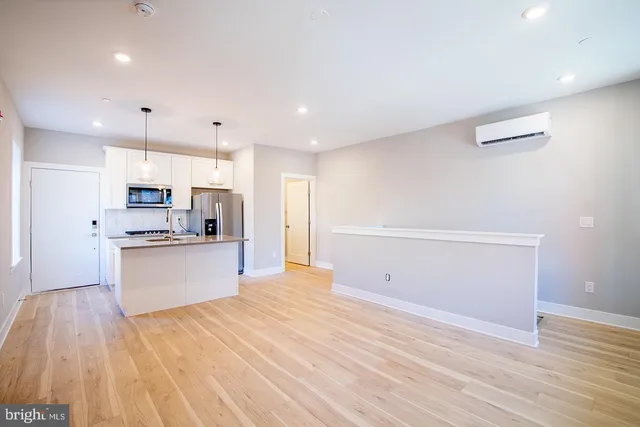 a view of kitchen with wooden floor and electronic appliances