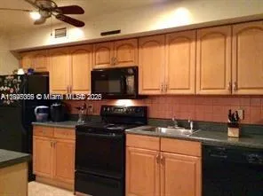 a kitchen with stainless steel appliances wooden cabinets a stove a sink and a microwave