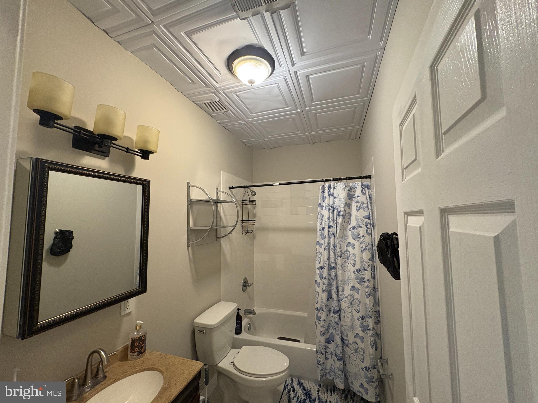 222 North Liberty Street, Unit 2 Baltimore, MD 21201 - Photo 8 of 15 a bathroom with a granite countertop bathtub shower sink mirror and toilet