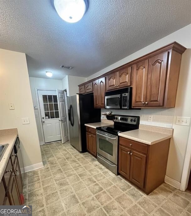 208 Sugarloaf Parkway Perry, GA 31069 - Photo 4 of 11 a kitchen with stainless steel appliances granite countertop a stove refrigerator and microwave