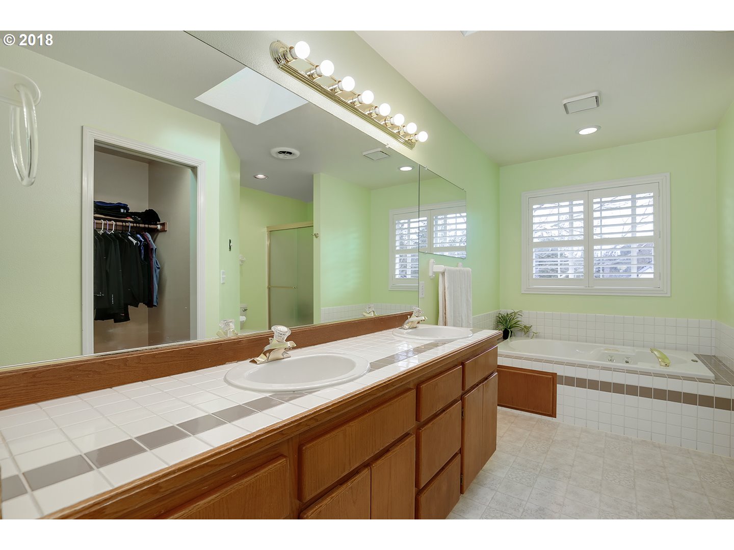 10470 Southwest 135th Avenue Beaverton, OR 97008 - Photo 26 of 32 a bathroom with a granite countertop sink a large mirror and a bathtub