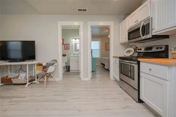 a kitchen with stainless steel appliances kitchen island granite countertop a stove and a wooden floor