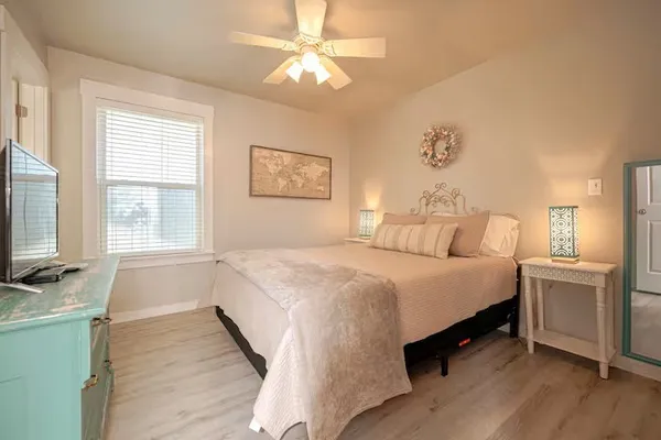 a spacious bedroom with a bed and a flat screen tv