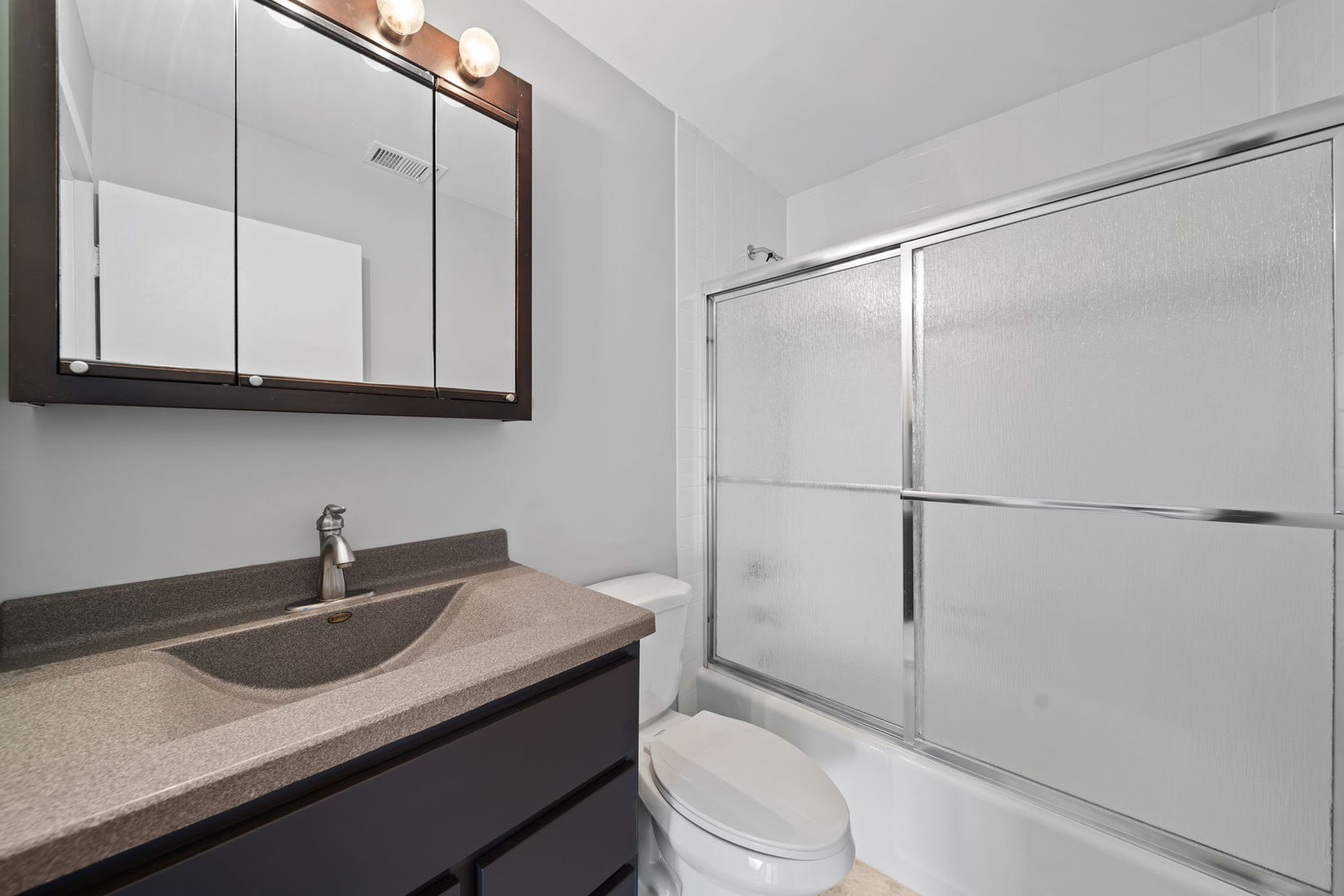 425 Walnut Creek Road, Unit 1401 Lisle, IL 60532 - Photo 10 of 19 a bathroom with a sink a mirror a toilet and shower