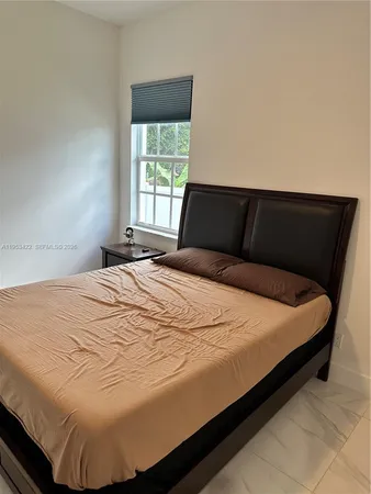a large bed sitting in a bedroom next to a window