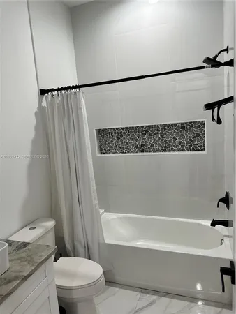 a bathroom with a shower a toilet and a sink