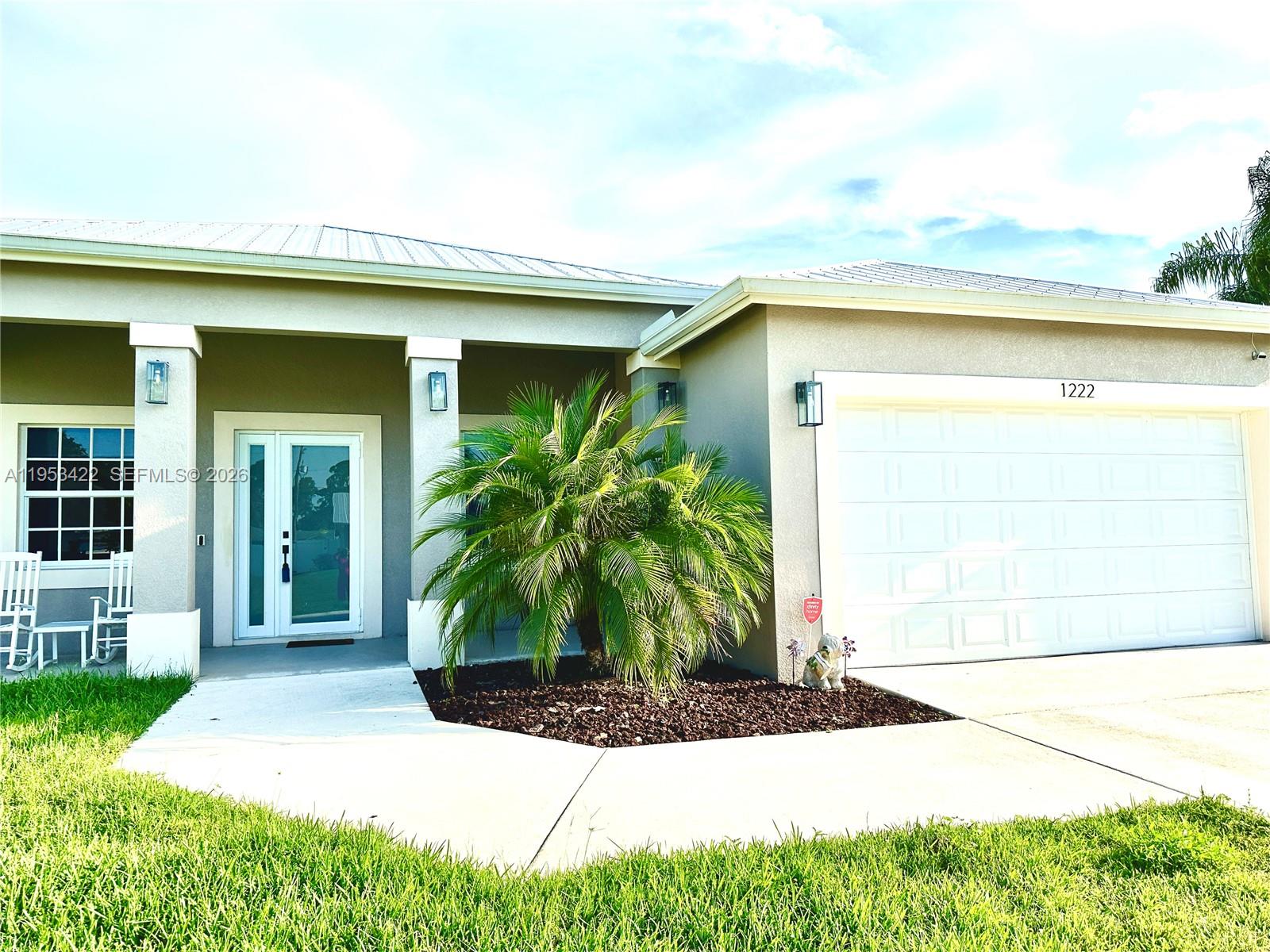 1222 Southwest Herald Road Port St. Lucie, FL 34953 - Photo 2 of 25 a front view of a house with garden