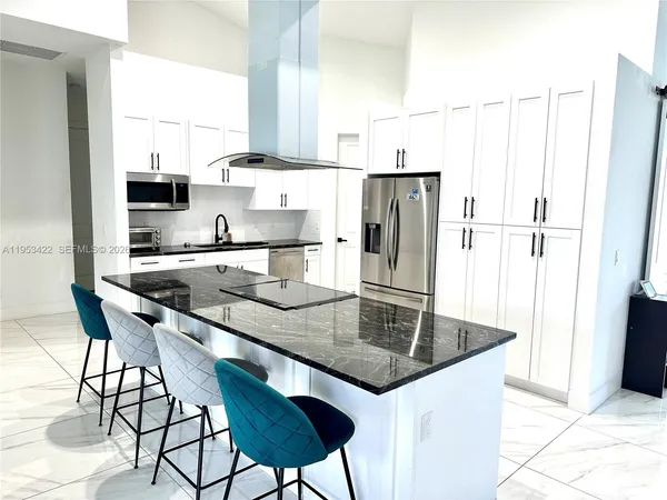 a kitchen with stainless steel appliances a sink a table and chairs