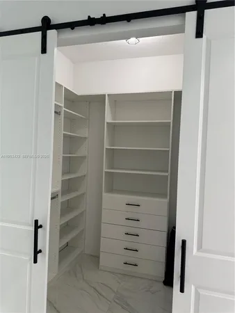 a view of walk in closet with empty racks