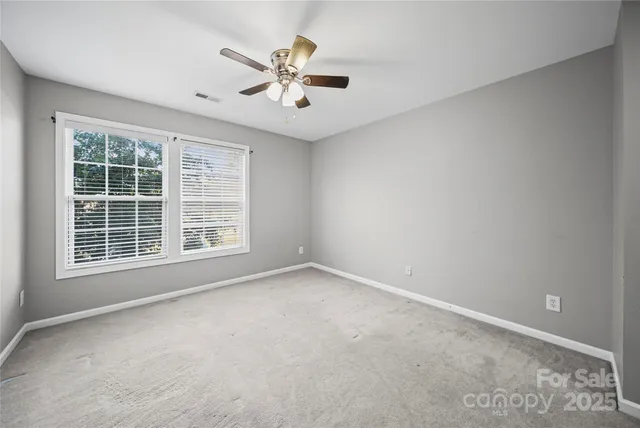 a spacious bedroom with a bed a couch and a window