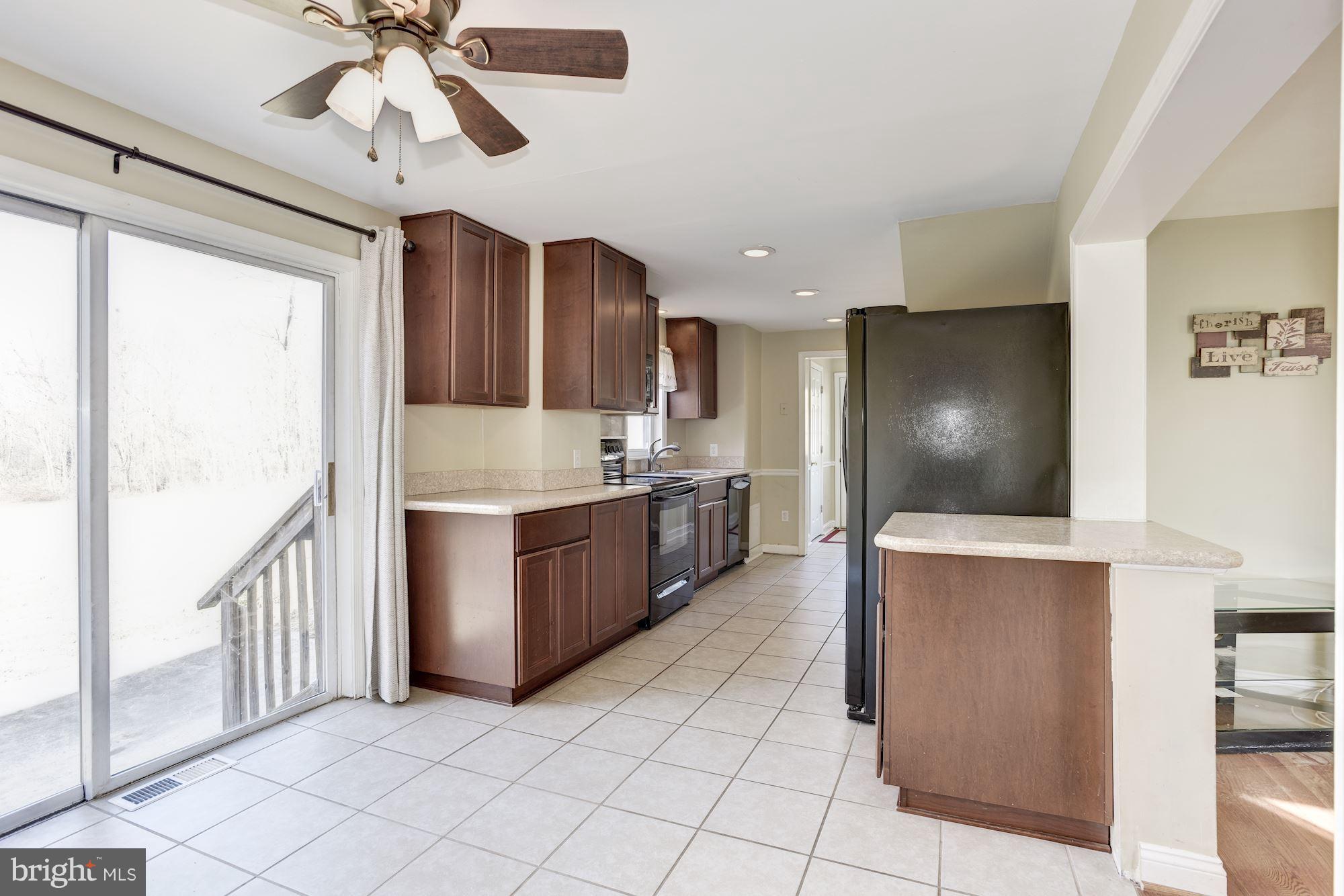 11914 Legore Bridge Road Keymar, MD 21757 - Photo 14 of 30 a kitchen with stainless steel appliances kitchen island granite countertop a refrigerator and a sink