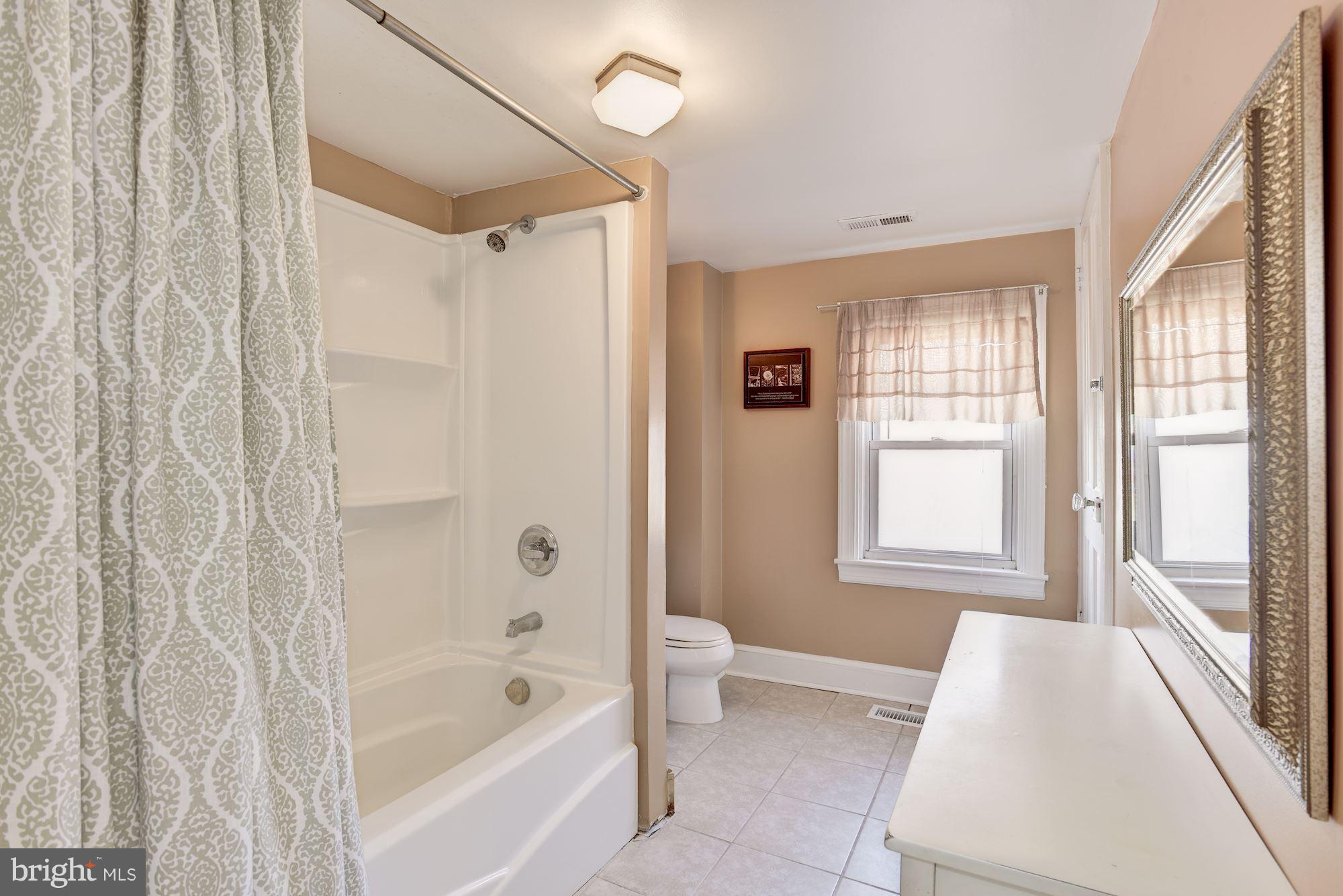 11914 Legore Bridge Road Keymar, MD 21757 - Photo 21 of 30 a bathroom with a bathtub a shower and a window