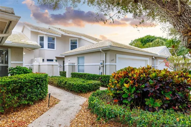 a front view of a house with a garden and plants