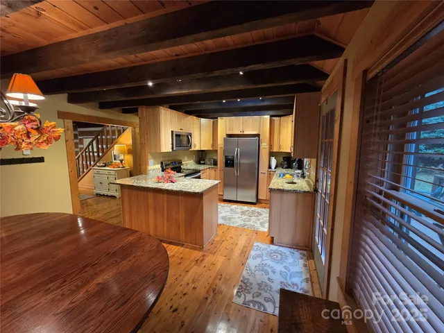 a kitchen with kitchen island granite countertop wooden cabinets and refrigerator