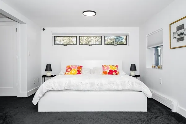 a white bed sitting in a bedroom and couch