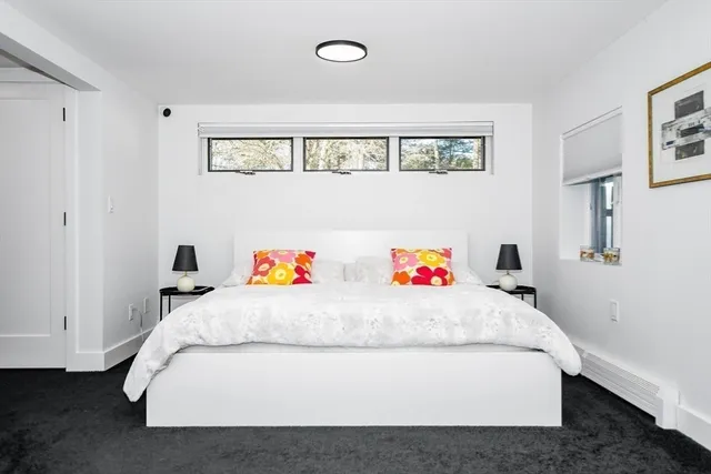 a white bed sitting in a bedroom next to a window