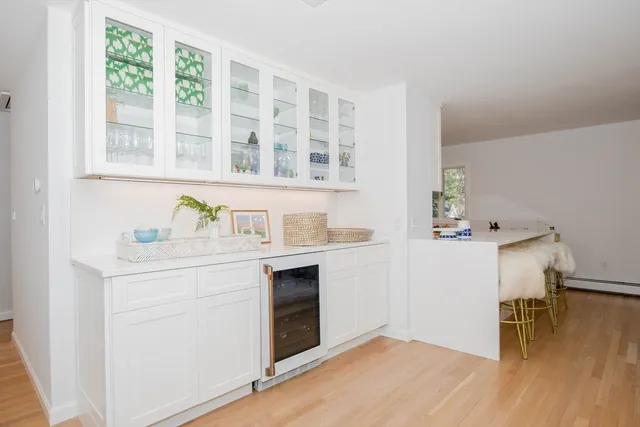 a hallway with a stove and a kitchen island with wooden floor