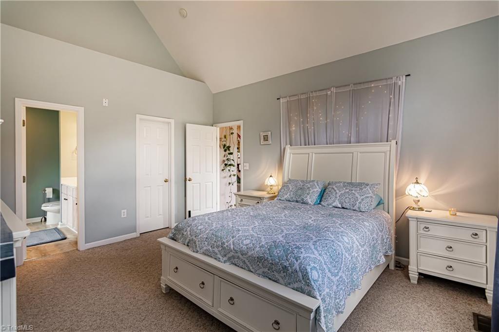 7611 Strawberry Road Summerfield, NC 27358 - Photo 10 of 22 The large master bedroom is on the main floor and features vaulted ceilings, and en-suite bath.