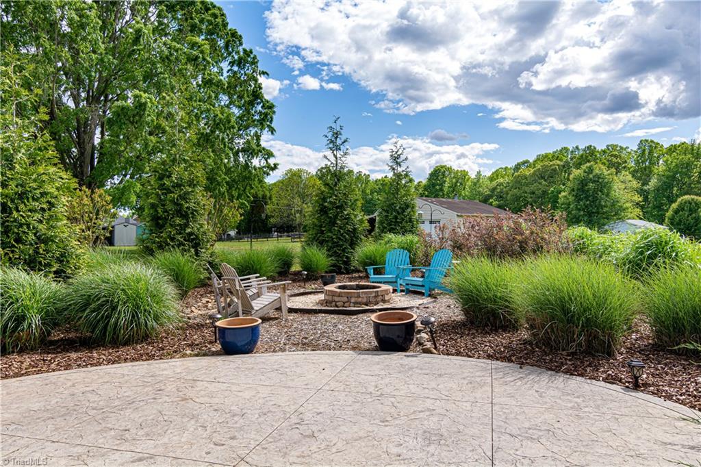 7611 Strawberry Road Summerfield, NC 27358 - Photo 17 of 22 Through the living room sliding doors, takes you to a backyard oasis. Complete with a gorgeous stone patio, and fireplace!