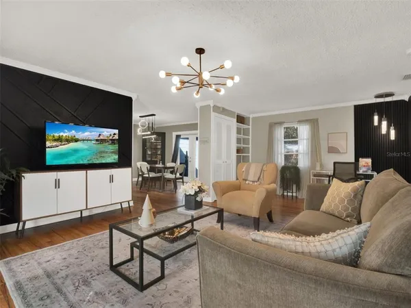a living room with furniture a flat screen tv and a table