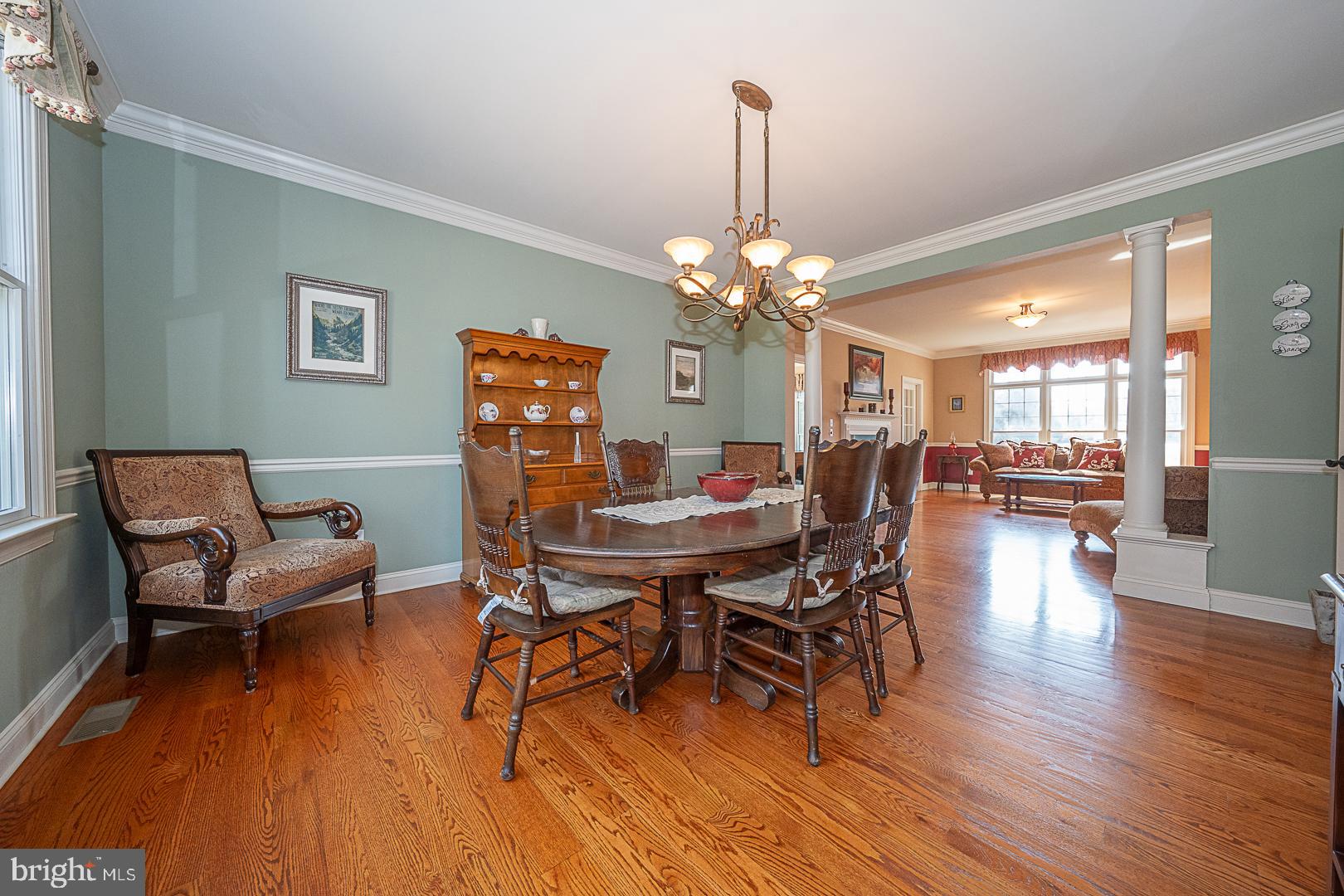 1545 Morstein Road Malvern, PA 19355 - Photo 5 of 41 a dining room with furniture wooden floor a rug a potted plant and a chandelier