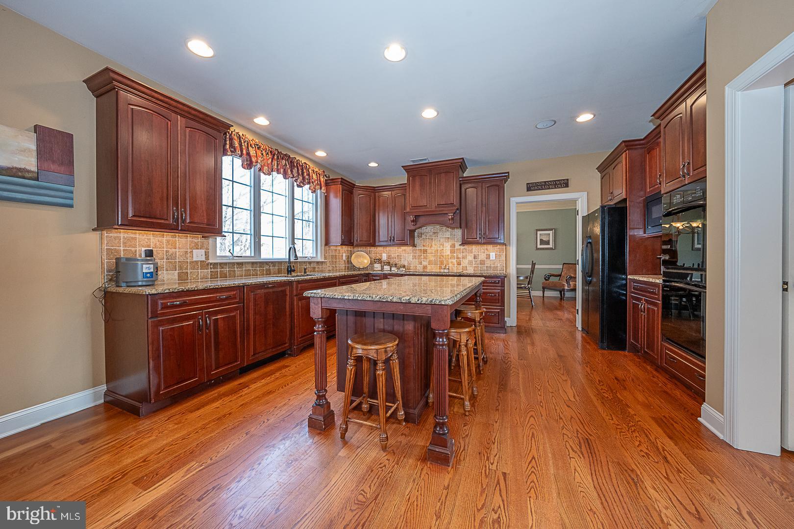 1545 Morstein Road Malvern, PA 19355 - Photo 7 of 41 a kitchen with stainless steel appliances kitchen island granite countertop wooden floors and wooden cabinets