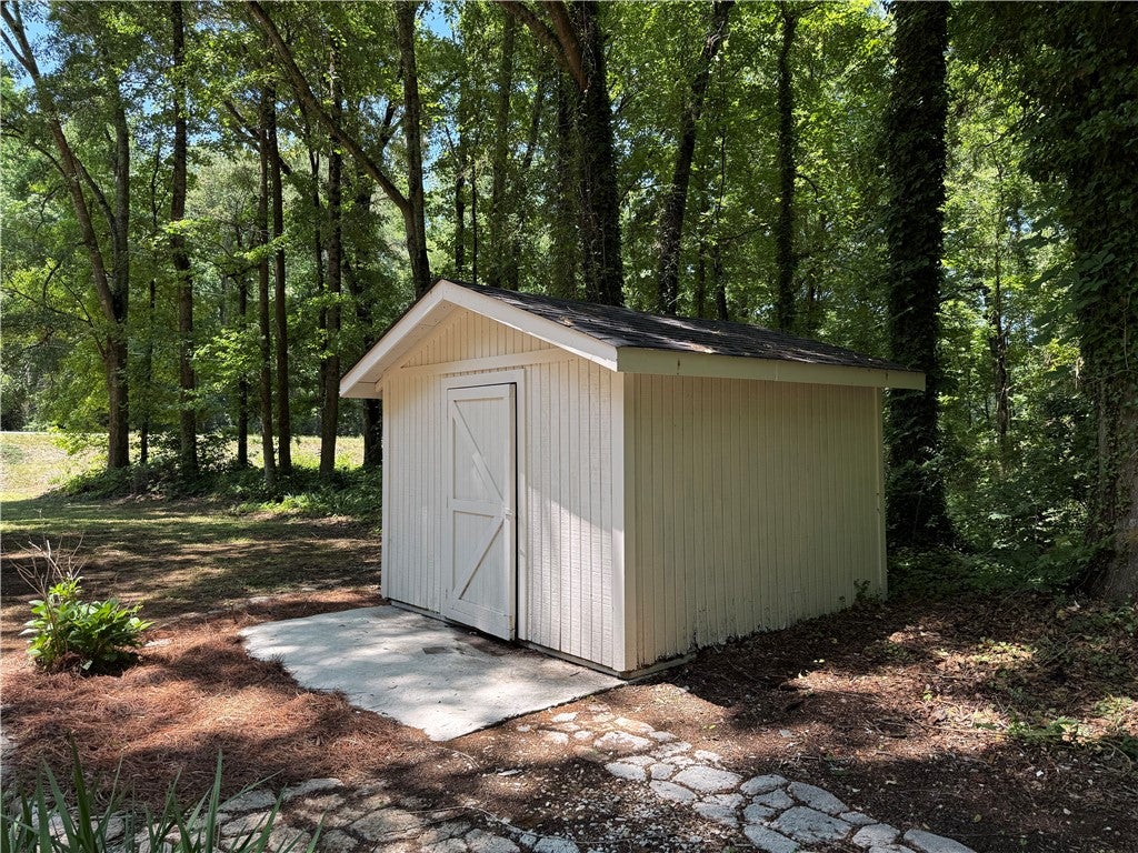 306 Crawford Road Opelika, AL 36804 - Photo 29 of 31 This outdoor shed provides functional storage amidst a tranquil, wooded setting.