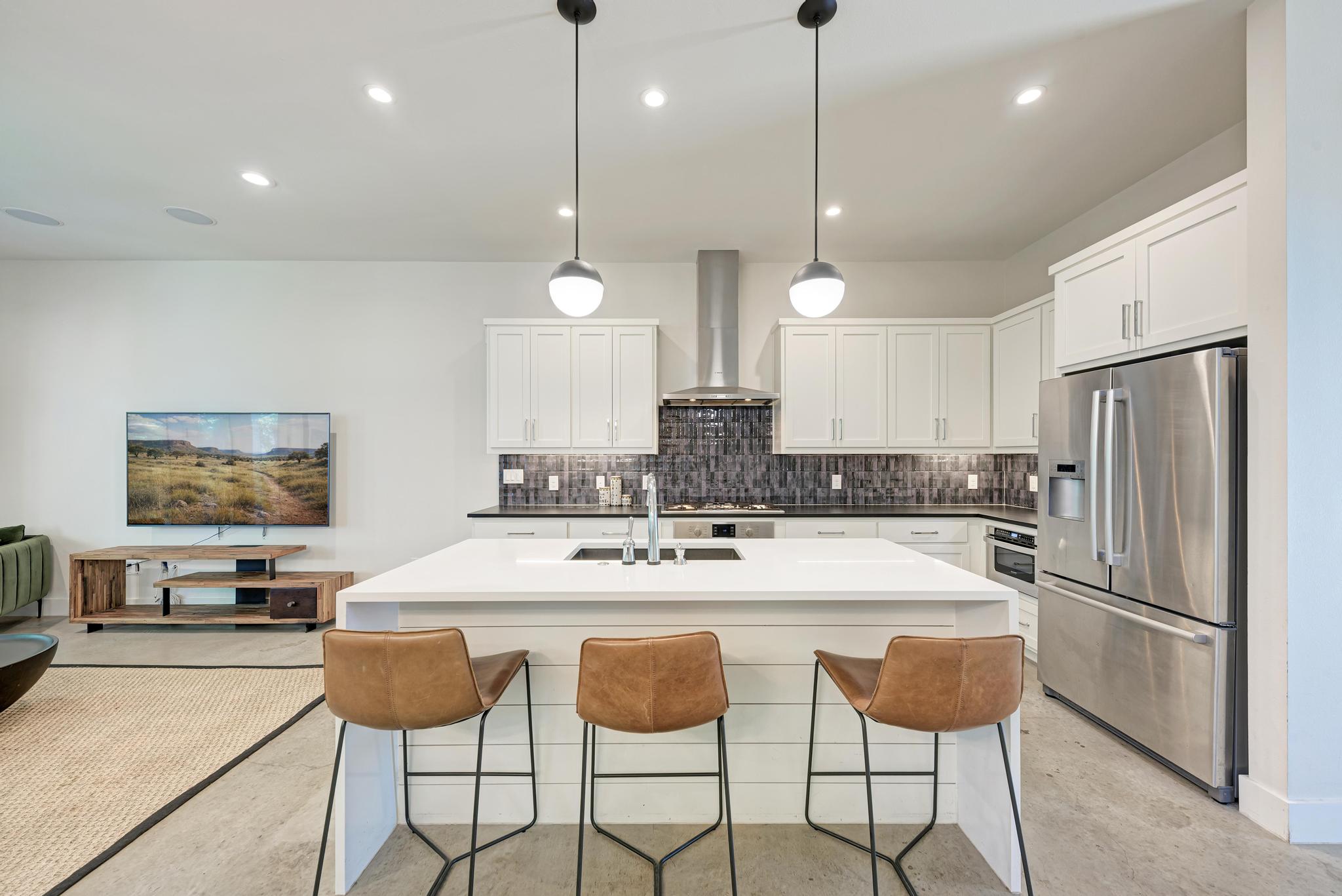 918 Cardinal Lane, Unit A Austin, TX 78704 - Photo 8 of 40 Exquisite gourmet kitchen with an oversized waterfall island illuminated by statement pendants above.