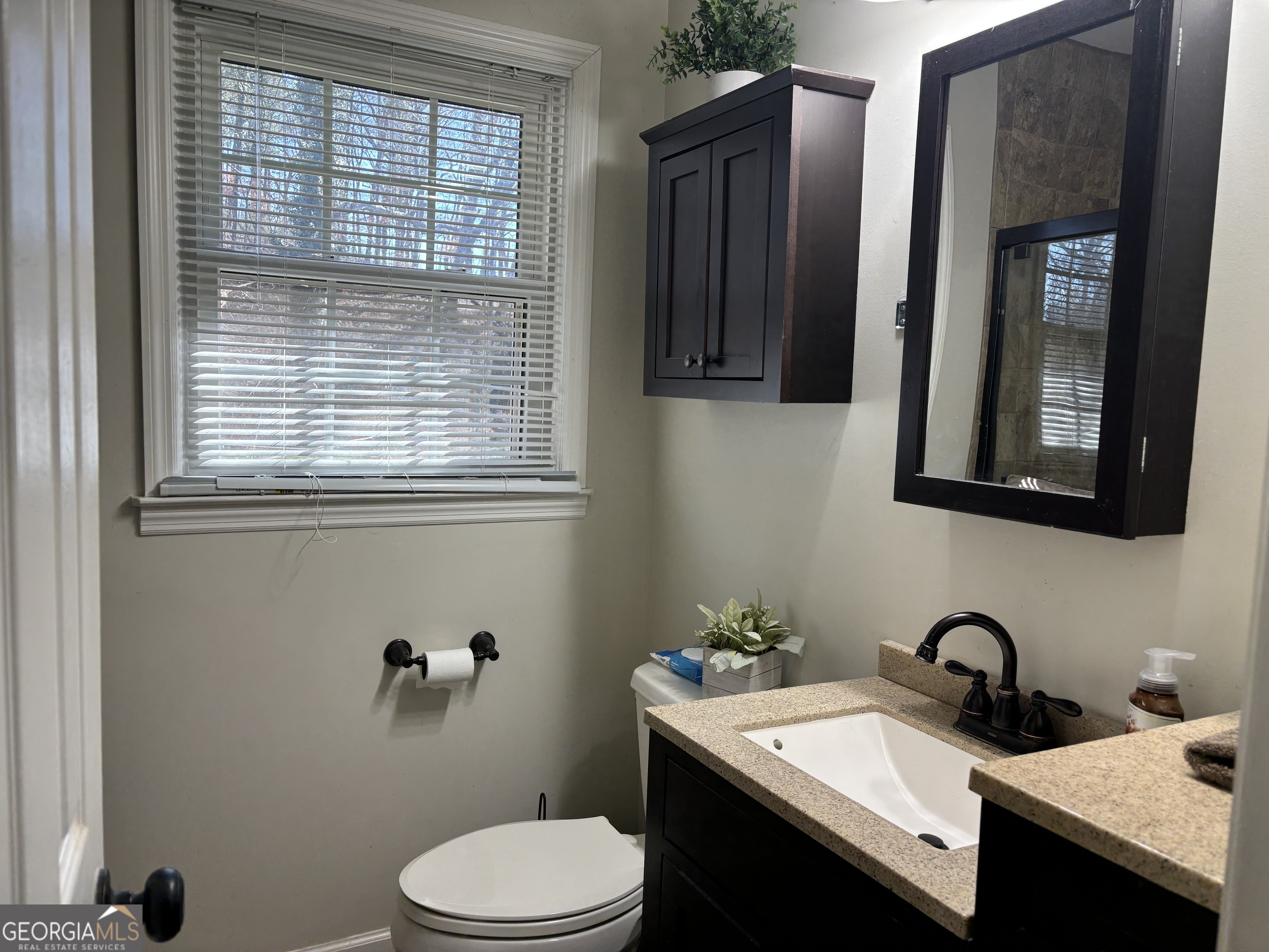 1517 Cave Spring Road Southwest Rome, GA 30161 - Photo 20 of 25 a bathroom with a granite countertop sink toilet and mirror