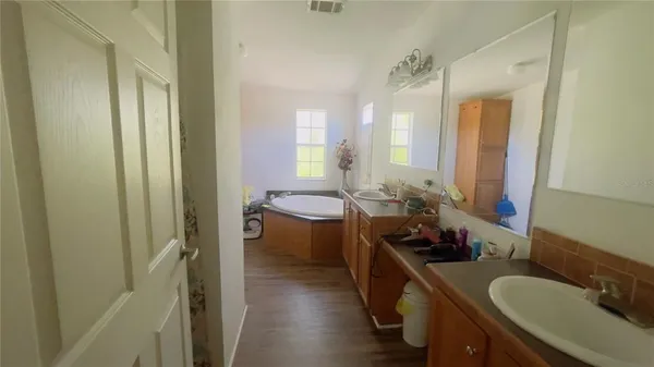 a spacious bathroom with a granite countertop sink mirror and a bathtub