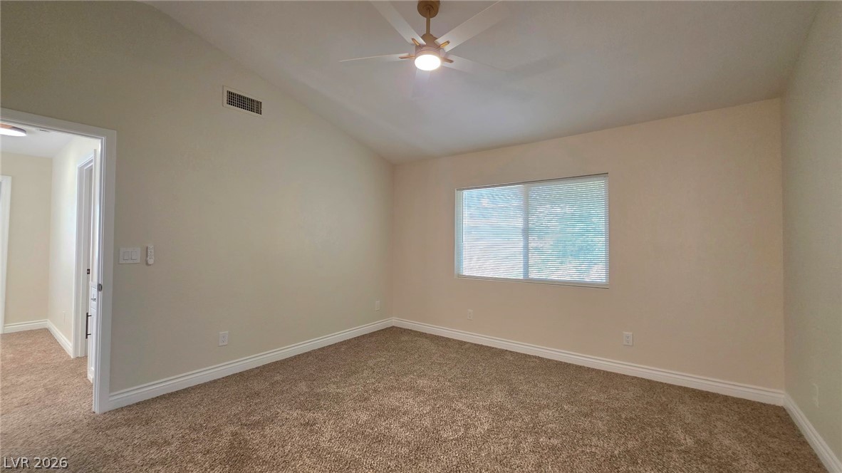 2155 Athol Way Laughlin, NV 89029 - Photo 8 of 19 A restful bedroom offers vaulted ceilings and comfortable carpet flooring.