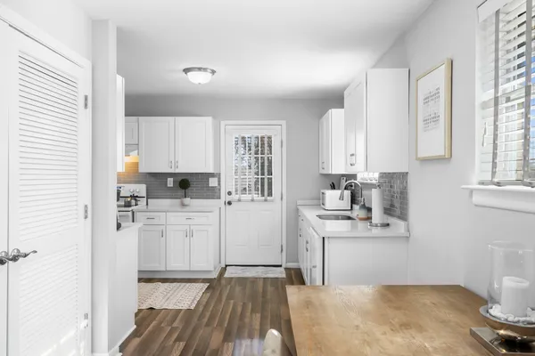 a kitchen with a sink cabinets stainless steel appliances and windows
