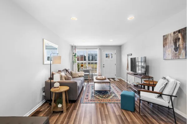 a living room with furniture and a wooden floor