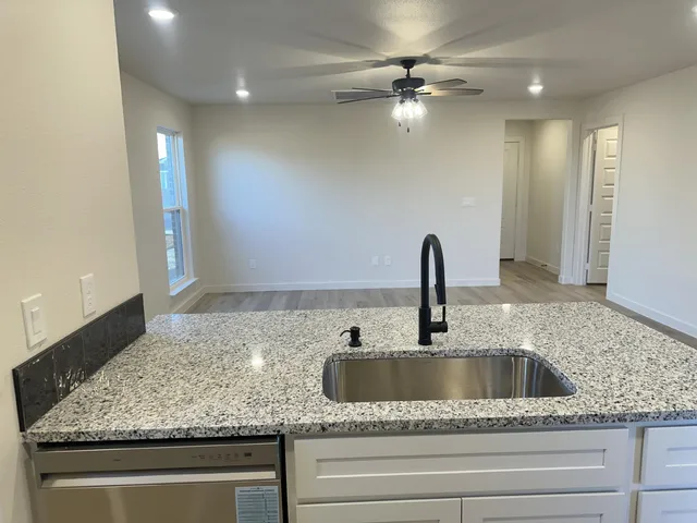 a kitchen with kitchen island a sink a stove and a microwave