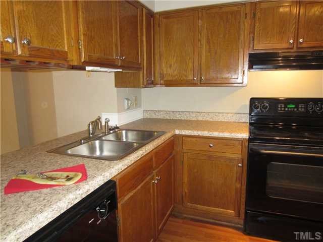 7704 Sandra Lane Raleigh, NC 27615 - Photo 3 of 17 a kitchen with stainless steel appliances granite countertop a sink stove and cabinets