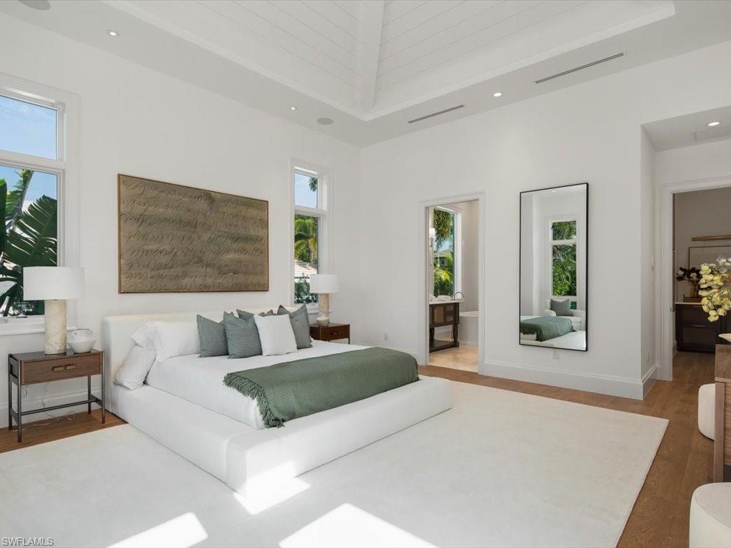 620 Binnacle Drive Naples, FL 34103 - Photo 21 of 49 Bedroom with hardwood / wood-style floors, a towering ceiling, and ensuite bathroom