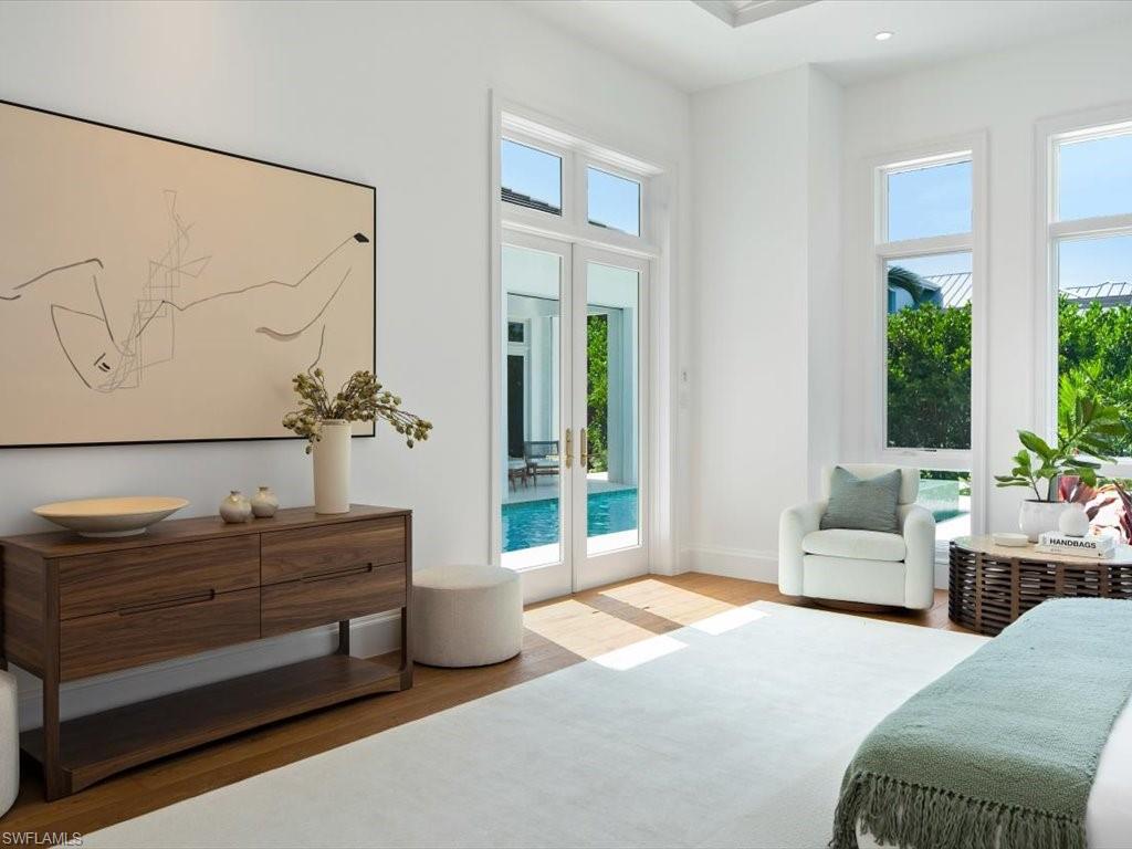 620 Binnacle Drive Naples, FL 34103 - Photo 26 of 49 Bedroom featuring access to exterior, multiple windows, and light hardwood / wood-style flooring