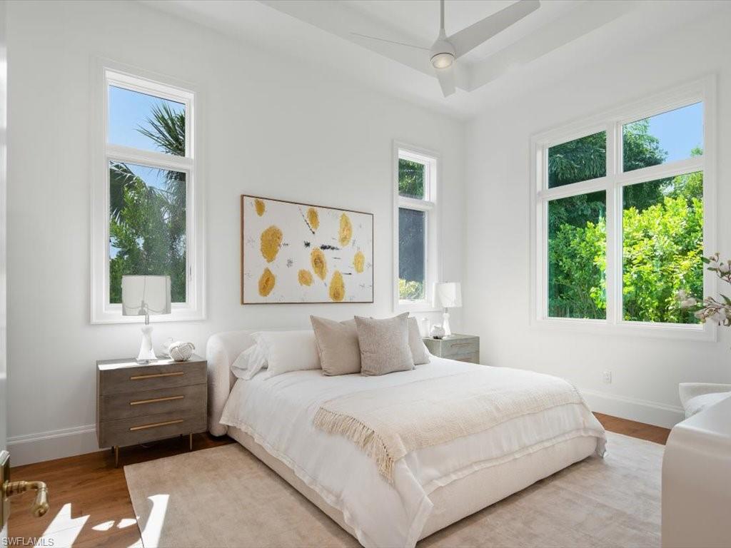 620 Binnacle Drive Naples, FL 34103 - Photo 30 of 49 Bedroom featuring ceiling fan, light hardwood / wood-style flooring, and multiple windows