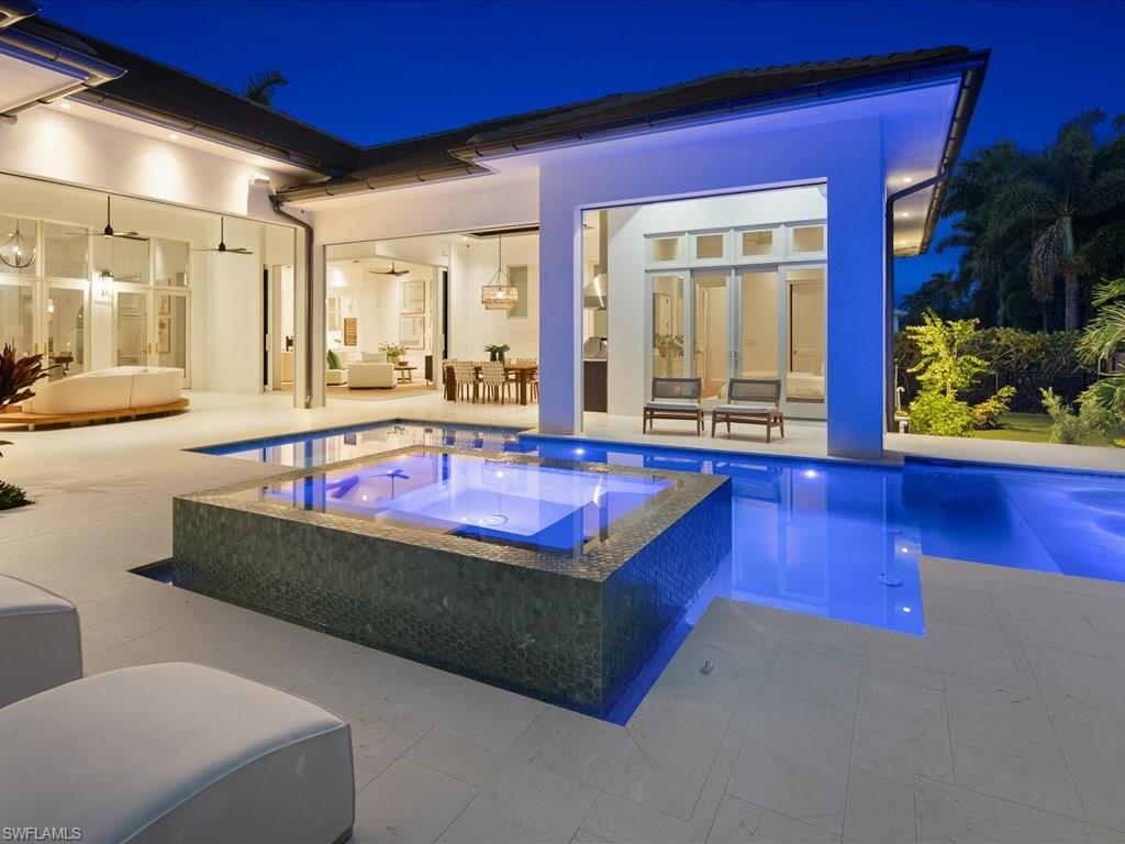 620 Binnacle Drive Naples, FL 34103 - Photo 38 of 49 Pool at twilight featuring an in ground hot tub, a patio, an outdoor living space, and ceiling fan