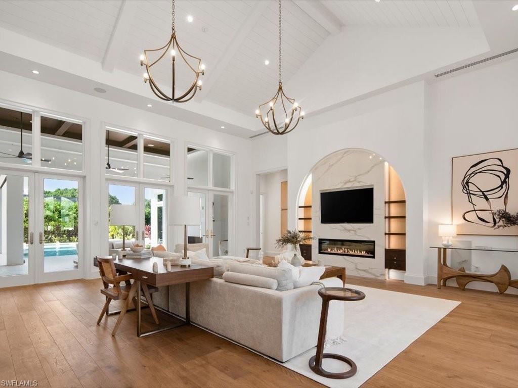 620 Binnacle Drive Naples, FL 34103 - Photo 4 of 49 Living room featuring wood-type flooring, beam ceiling, french doors, and high vaulted ceiling