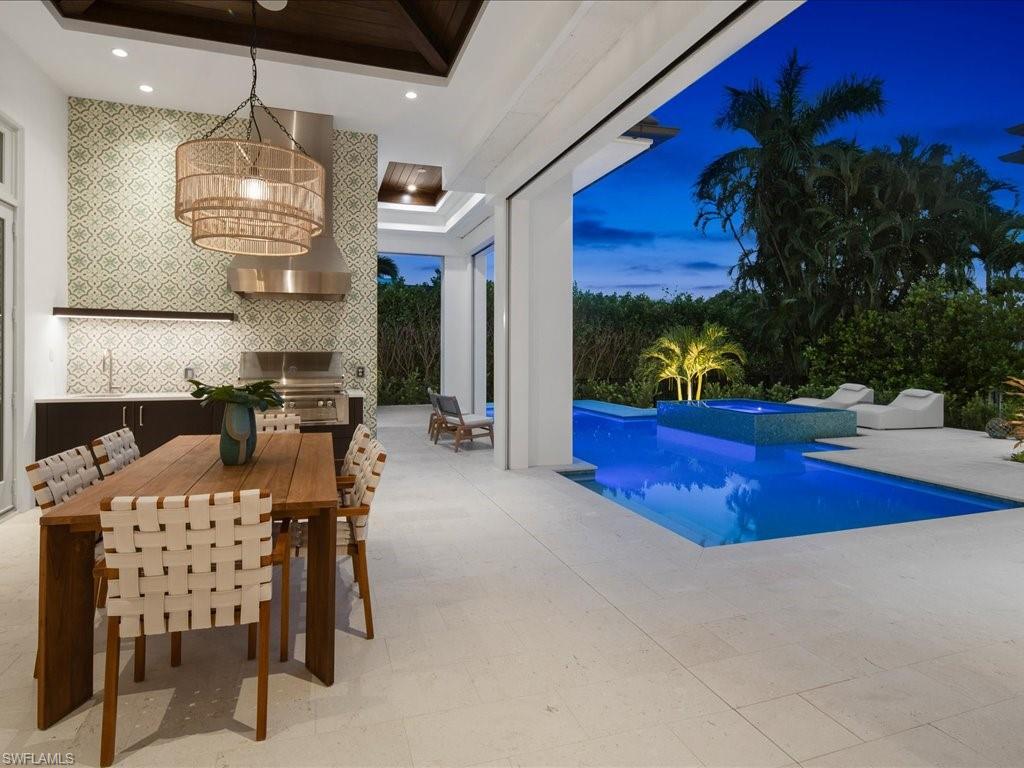 620 Binnacle Drive Naples, FL 34103 - Photo 43 of 49 Pool at dusk with a notable chandelier and a grill