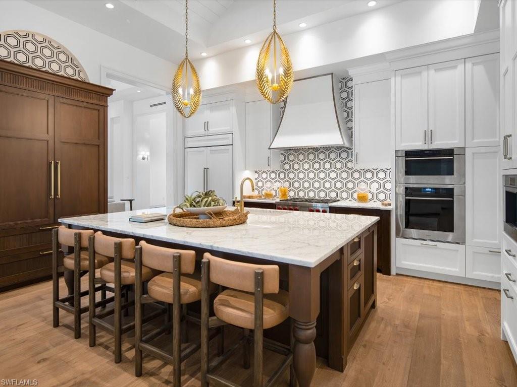 620 Binnacle Drive Naples, FL 34103 - Photo 8 of 49 Kitchen with white cabinets, an island with sink, appliances with stainless steel finishes, and sink