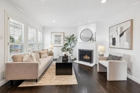 a view of a dining room and livingroom with furniture wooden floor a chandelier
