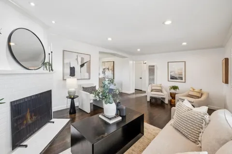 a kitchen with stainless steel appliances granite countertop a sink a stove a refrigerator a center island with wooden floor and cabinets