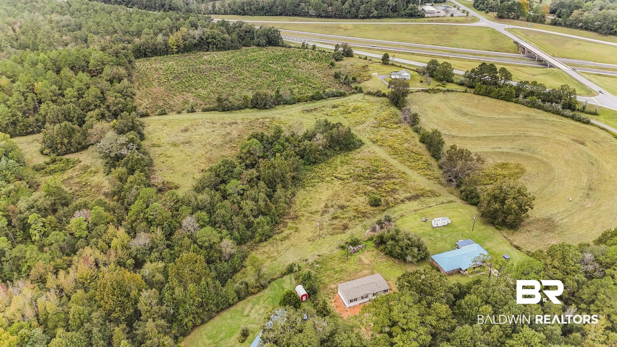54309 Klasnich Road Perdido, AL 36562 - Photo 26 of 29 Aerial view of property and surrounding area featuring rural landscape and a tree filled landscape