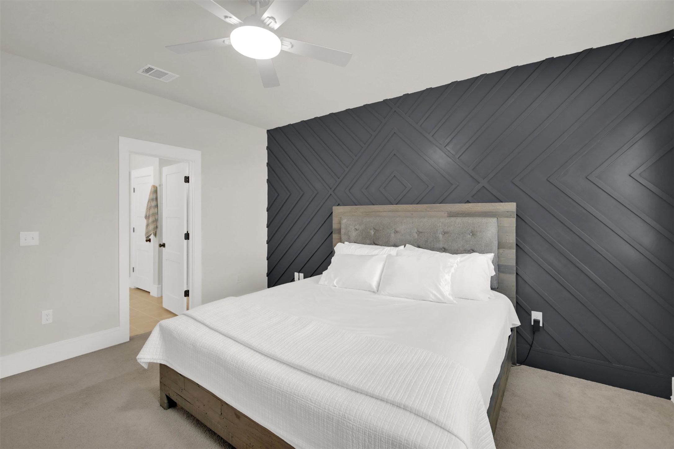 964 Pepperbark Loop Buda, TX 78610 - Photo 16 of 35 Bedroom with an accent wall, light carpet, and ceiling fan