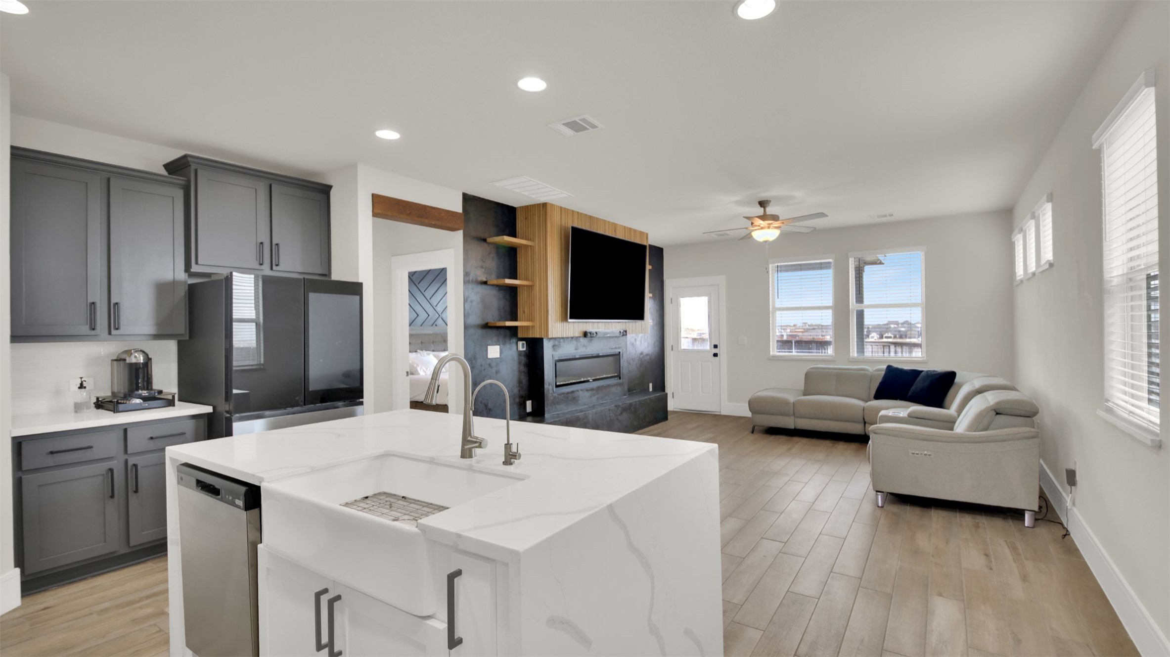 964 Pepperbark Loop Buda, TX 78610 - Photo 23 of 23 Dual tone kitchen featuring open floor plan, light wood-style floors, black refrigerator, an island with sink, and recessed lighting